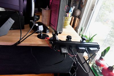 Power strip clamped to desk, and a couple more outlets embedded.